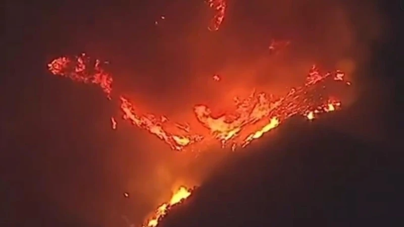 Article from www.news.com.au with the title Hollywood Hills erupts in flames as wildfires continue to rage across LA